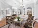 Expansive living room flowing into dining area & kitchen; features elegant columns, hardwood floors, and natural light at 7921 Waterton Ln, Lakewood Ranch, FL 34202