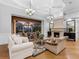 Bright living room with coffered ceilings, a fireplace and seamless access to the outdoor pool area at 7921 Waterton Ln, Lakewood Ranch, FL 34202