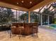 Outdoor patio bar with a wood counter and seating overlooking the pool and lush landscaping at 7921 Waterton Ln, Lakewood Ranch, FL 34202