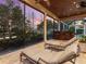 Screened patio with lounge chairs overlooking lush greenery and a serene pond, ideal for relaxation and outdoor enjoyment at 7921 Waterton Ln, Lakewood Ranch, FL 34202