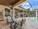 Expansive covered patio with seating, dining, and bar areas, offering an ideal outdoor living space by the pool at 7921 Waterton Ln, Lakewood Ranch, FL 34202