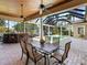Covered patio with dining table and chairs set near the pool and screened enclosure at 7921 Waterton Ln, Lakewood Ranch, FL 34202