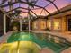 Screened in-ground pool and spa reflecting the colorful sunset on a private property at 7921 Waterton Ln, Lakewood Ranch, FL 34202