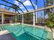 Enclosed pool with spa, water feature, and covered patio featuring outdoor kitchen and dining at 7921 Waterton Ln, Lakewood Ranch, FL 34202