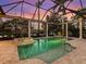 Screened-in pool and spa with stone surround, columns, and an expansive view of the lake at 7921 Waterton Ln, Lakewood Ranch, FL 34202