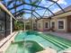 Enclosed in-ground pool and spa surrounded by patio with many large windows and palm trees at 7921 Waterton Ln, Lakewood Ranch, FL 34202