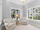 Bright sitting area features two comfortable chairs, a glass table, and large windows at 7921 Waterton Ln, Lakewood Ranch, FL 34202