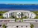 Scenic aerial view of a waterfront condominium complex with covered parking and lush landscaping near the water at 1020 Tidewater Shores Loop # 107, Bradenton, FL 34208