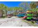 Canoe and Kayak storage area with several colorful boats surrounded by lush, tropical foliage at 1020 Tidewater Shores Loop # 107, Bradenton, FL 34208