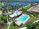 Aerial of the community pool and clubhouse, with lounge seating surrounded by lush landscaping at 1020 Tidewater Shores Loop # 107, Bradenton, FL 34208