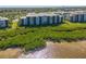 Waterfront condo building with mature landscaping and lush vegetation alongside the water at 1020 Tidewater Shores Loop # 107, Bradenton, FL 34208