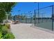 Fenced tennis court area with tables and chairs offering recreational opportunities for residents at 1020 Tidewater Shores Loop # 107, Bradenton, FL 34208
