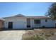 Charming single-story home with a well-maintained lawn, a driveway, and a one car garage on a sunny day at 1027 Newton St, Englewood, FL 34224
