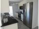 Modern kitchen with stainless steel appliances, white cabinetry, and sleek black countertops at 1027 Newton St, Englewood, FL 34224