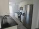 Modern kitchen with stainless steel appliances, white cabinetry, and sleek black countertops at 1027 Newton St, Englewood, FL 34224