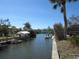 Picturesque waterfront view showcasing a serene canal lined with lush greenery and private boat docks under a clear blue sky at 1027 Newton St, Englewood, FL 34224