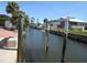 Scenic waterfront view of a canal with boat docks, lush greenery, and clear blue skies, perfect for boating enthusiasts at 1027 Newton St, Englewood, FL 34224