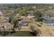 Aerial shot of a property featuring a screened pool, backing onto a tranquil pond amidst lush greenery at 1127 133Rd E St, Bradenton, FL 34212