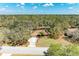 Stunning aerial view of a home surrounded by a dense forest and pond at 1127 133Rd E St, Bradenton, FL 34212