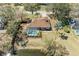 Aerial view of home with screened-in pool, pond, fenced backyard, and mature trees at 1127 133Rd E St, Bradenton, FL 34212