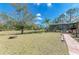 Spacious backyard with a serene pond view, complete with a fire pit and screened-in pool area at 1127 133Rd E St, Bradenton, FL 34212