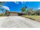 Well-maintained single-story home showcasing a large driveway and meticulously landscaped front yard at 1127 133Rd E St, Bradenton, FL 34212