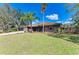 Charming single-story brick home boasting mature palm trees and a well-manicured lawn at 1127 133Rd E St, Bradenton, FL 34212