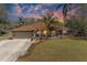 Charming single-story brick home with lush landscaping, mature palms, and a two-car garage at 1127 133Rd E St, Bradenton, FL 34212
