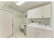 Well-lit laundry room equipped with modern washer and dryer, complemented by cabinetry and a utility sink at 1127 133Rd E St, Bradenton, FL 34212