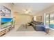 Open-concept living room with a leather sofa, television, tile floors, and vaulted ceilings at 1127 133Rd E St, Bradenton, FL 34212