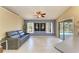 Inviting living room with slider doors to the pool area, bright blue accent wall and tile floors at 1127 133Rd E St, Bradenton, FL 34212