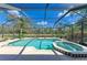Sparkling pool and jacuzzi inside enclosure with views of private backyard and lush greenery at 1127 133Rd E St, Bradenton, FL 34212