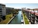 An aerial view showcasing waterfront condos with private docks, lush landscaping, and a tranquil canal at 1250 N Portofino Dr # 201, Sarasota, FL 34242