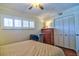 Bright bedroom features wood floors, a ceiling fan, shuttered windows, and a closet at 1250 N Portofino Dr # 201, Sarasota, FL 34242