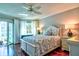 Cozy bedroom with ceiling fan, hardwood floors, and access to a private balcony at 1250 N Portofino Dr # 201, Sarasota, FL 34242