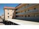 Multi-story condo building with white railings, beige exterior and covered parking at 1250 N Portofino Dr # 201, Sarasota, FL 34242