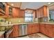 Charming kitchen featuring stainless steel appliances, tile backsplash, and wood cabinetry at 1250 N Portofino Dr # 201, Sarasota, FL 34242