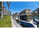 Picturesque waterfront view with boats docked along the canal and lush tropical landscaping at 1250 N Portofino Dr # 201, Sarasota, FL 34242