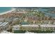 This aerial view showcases canal-front condos near the beach, tennis courts, and tropical landscape at 1250 N Portofino Dr # 303, Sarasota, FL 34242