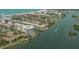 This aerial view showcases a coastal community with canal-front condos, tennis courts, and water access at 1250 N Portofino Dr # 303, Sarasota, FL 34242