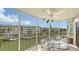 Relaxing screened-in balcony with ceiling fan overlooking a canal with boats and views of the condos at 1250 N Portofino Dr # 303, Sarasota, FL 34242