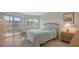 Comfortable bedroom with a balcony, large windows, and neutral decor with tile floors at 1250 N Portofino Dr # 303, Sarasota, FL 34242