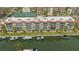 Condo building exterior with boats docked along canal and tennis courts in the background at 1250 N Portofino Dr # 303, Sarasota, FL 34242