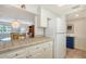 Spacious kitchen featuring ample counter space, white cabinetry and refrigerator, connected to the dining area at 1250 N Portofino Dr # 303, Sarasota, FL 34242