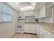 Well-lit kitchen with white appliances, tiled floors, and ample cabinet space at 1250 N Portofino Dr # 303, Sarasota, FL 34242