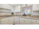 Bright kitchen showcasing white cabinets, tile countertops, and an open design to the dining area at 1250 N Portofino Dr # 303, Sarasota, FL 34242