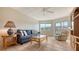 Bright and airy living room features a comfortable blue couch, glass coffee table, and lots of light at 1250 N Portofino Dr # 303, Sarasota, FL 34242