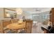Bright living room features wood dining set and table lamps, leading to the sliders to screened patio at 1250 N Portofino Dr # 303, Sarasota, FL 34242
