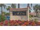Elegant Siesta Harbor community sign surrounded by colorful flowers and lush landscaping at 1250 N Portofino Dr # 303, Sarasota, FL 34242
