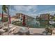 Picturesque waterfront view with boats docked, tables, chairs, and lush landscaping on a brick-paved patio at 1250 N Portofino Dr # 303, Sarasota, FL 34242